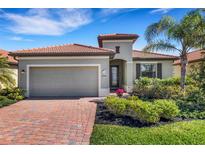 Charming single-story home features a red tile roof, brick paved driveway and manicured landscaping at 19340 Bluff Dr, Venice, FL 34292