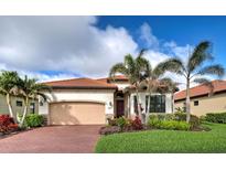 Charming single-story home featuring a red tile roof, beautiful landscaping and brick driveway at 23415 Waverly Cir, Venice, FL 34293