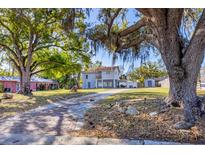 Charming two-story home featuring an inviting brick driveway and beautiful mature trees shading the property at 3052 Alta Vista St, Sarasota, FL 34237