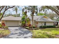Single-story home featuring a neutral color palette, tile roof, attached garage, and mature landscaping at 311 Pembroke Dr # 217, Venice, FL 34293