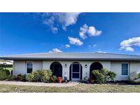 Charming single-story home featuring arched entryways, a tile roof, and mature landscaping against a bright blue sky at 456 Matisse S Cir # 456, Nokomis, FL 34275