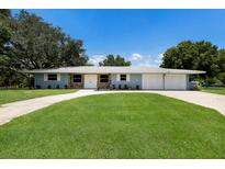 Charming single-story home featuring a stone accent, a well-manicured lawn, and an extra wide driveway at 651 Percheron Cir, Nokomis, FL 34275