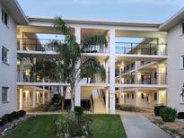 A three-story building exterior with walkways, landscaping, and stairs to each of the units at 708 Tamiami S Trl # 110, Venice, FL 34285