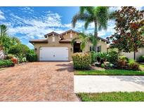 Charming single-story home with a brick driveway, lush landscaping, and a two-car garage at 1088 Bluffwood Dr, Nokomis, FL 34275