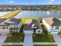 Aerial view of home featuring a lake view with fountain and well-maintained landscaping at 12637 Promenade Estates Blvd, Sarasota, FL 34238