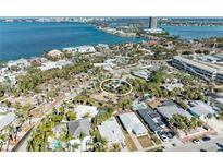 An aerial view shows a home surrounded by lush landscaping and trees with a glimpse of the bay in the background at 153 N Adams Dr, Sarasota, FL 34236