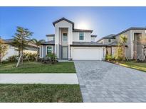 Beautiful two-story home featuring a two-car garage, well-manicured lawn, and neutral-colored accents at 17449 Luminous Ave, Venice, FL 34293