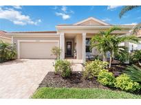 Charming single-story home with lush landscaping, brick driveway, and inviting front porch at 20389 Minuet Pl, Venice, FL 34293