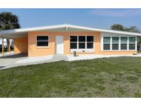 Charming single-story home with a well-manicured lawn, covered carport and clean landscaping at 231 Redwood Rd, Venice, FL 34293