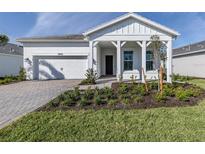 Charming single-story home featuring a well-manicured lawn, paver driveway, and a welcoming porch at 29176 Coral Harbour Dr, Englewood, FL 34223