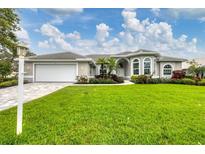 Inviting single-story home features a well-manicured lawn and lush landscaping, enhancing its curb appeal at 394 Hanchey Dr, Nokomis, FL 34275