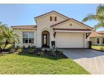 Charming single-story home with a red tile roof, two-car garage, and well-maintained landscaping at 500 Padova Way, North Venice, FL 34275