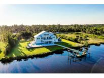 Stunning waterfront home with private dock, pool, and lush landscaping at 9061 Kellogg Ln, Venice, FL 34293