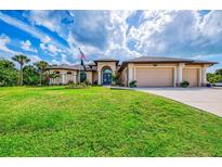 Beautiful home featuring manicured lawn, multi car garage and arched entry way at 9407 Prospect Ave, Englewood, FL 34224