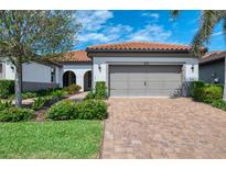Charming home featuring a brick driveway, neutral paint scheme, and tile roof at 11810 Tapestry Ln, Venice, FL 34293