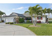 Charming single-story home featuring tropical landscaping, palm trees, and a well-manicured lawn at 1300 Lucaya Ave, Venice, FL 34285