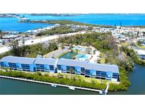Beautiful waterfront building with community pool, tennis courts, and lush landscaping at 1401 S Mccall Rd # 106, Englewood, FL 34223