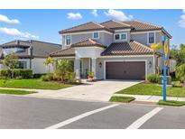 Charming two-story home with a well-manicured lawn, neutral paint, brown garage door and tile roof at 228 Caserta Ct, North Venice, FL 34275