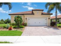 Charming single-story home featuring a tile roof, brick driveway, and well-maintained landscaping at 24036 Spartina Dr, Venice, FL 34293