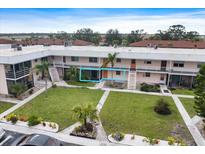 Two-story condo building showcasing well-maintained landscaping and walkways at 400 Base E Ave # 213, Venice, FL 34285