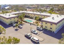 Overhead view of condo building, showcasing courtyard, parking, and community pool at 409 Manatee Ct # 104, Venice, FL 34285