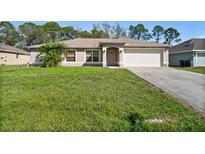 Charming single-story home featuring a well-maintained lawn and an attached two-car garage at 5458 Jessamine Ave, North Port, FL 34291