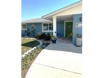 Inviting home entrance with a colorful green front door and well-maintained landscaping at 599 Carmel Rd, Venice, FL 34293