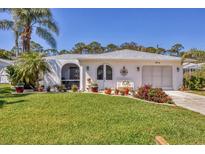 Charming single-story home with a well-manicured lawn, mature landscaping, and a welcoming front entrance at 6216 Pecan Rd, Venice, FL 34293