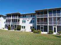 Exterior view of a two-story condo complex with screened balconies and well-maintained landscaping at 649 S Tamiami S Trl # 304, Venice, FL 34285