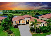 Stunning sunset view of a single-Gathering home featuring tile roof, paver driveway, and lush landscaping at 10742 Ironbridge Dr, Venice, FL 34293