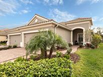 Inviting single-story home featuring a tiled roof, brick driveway, and lush landscaping at 11575 Okaloosa Dr, Venice, FL 34293