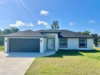Charming single-story home featuring a modern design, well-kept lawn and two-car garage at 12390 Talavera St, North Port, FL 34287