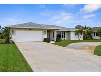 Well maintained house with a two-car garage, mature palms and landscaping and large driveway at 1726 Claw Ct, Venice, FL 34293