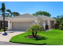 Charming single-story home with a two-car garage, well-manicured lawn, and mature landscaping at 1833 Lancashire Dr, Venice, FL 34293