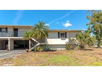 Charming condo with tropical landscaping, carport, and private access stairs at 4260 Placida Rd # 25D, Englewood, FL 34224