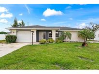 Charming single-story home with a well-maintained lawn, lush landscaping, and a convenient attached garage at 427 Canterbury Rd, Venice, FL 34293