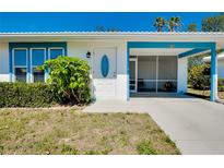 Charming single-story home featuring a screened-in porch, blue trim and well-maintained landscaping at 616 Circlewood Dr # S2-14, Venice, FL 34293