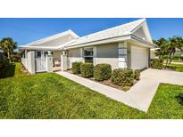 Charming single-story home with well-manicured lawn, white tile roof, and inviting front entrance at 782 Harrington Lake N Dr # 99, Venice, FL 34293