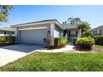 Charming single-story home featuring a well-manicured lawn, attached garage, and mature landscaping at 835 Chalmers Dr # 835, Venice, FL 34293