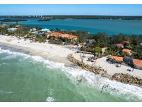 Stunning aerial view of a beachfront estate with turquoise waters and a sandy beach at 1049 N Casey Key Rd, Osprey, FL 34229