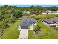 Aerial view of a house with a well-manicured lawn and landscaping at 1207 Henning St, North Port, FL 34288