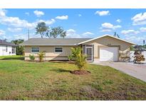 Charming single-story home showcases manicured front yard with lush lawn and vibrant landscaping at 308 Purdue Rd, Venice, FL 34293