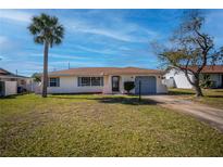Charming single-story home with a well-manicured lawn and a driveway leading to an attached garage at 358 Pineview Dr, Venice, FL 34293