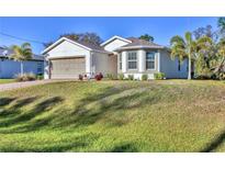 Two-story home featuring a two-car garage and a manicured lawn in a suburban neighborhood at 4324 Knowles Ln, North Port, FL 34288