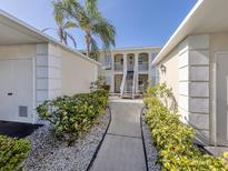 Inviting condo exterior with lush landscaping and a walkway leading to the building entrance at 435 Cerromar Ln # 326, Venice, FL 34293