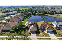 Beautiful aerial view of homes surrounding a tranquil lake and golf course, showcasing a serene community setting at 456 Pinewood Lake Dr, Venice, FL 34285