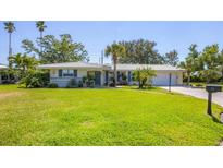 Charming single-story home with a well-manicured lawn and lush landscaping at 51 Oakwood N Dr # 51, Englewood, FL 34223