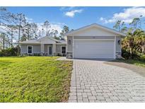 Charming single-story home showcasing a paved driveway and well-manicured lawn at 5761 Centro Ave, North Port, FL 34288