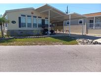 Charming home with covered parking featuring lush landscaping and a well-maintained lawn at 805 S Waterway, Venice, FL 34285