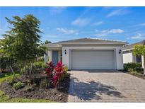 Beautiful single-story home featuring a manicured lawn and a welcoming two-car garage at 9800 Bright Water Dr, Englewood, FL 34223